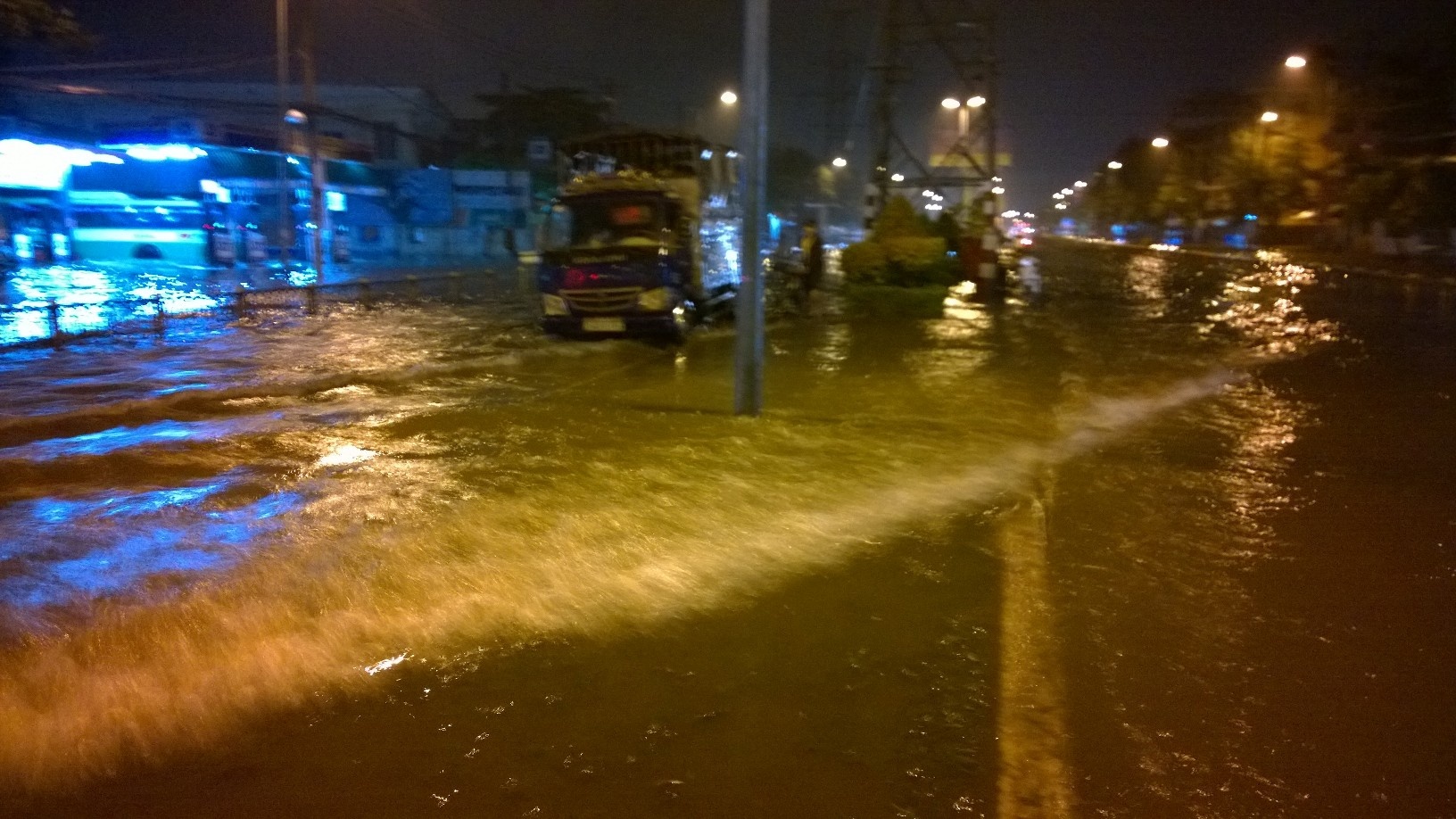 Nước ngập con lươn trên đường Kinh Dương Vương, phương tiện lớn chạy qua tạo sóng đánh ngã người đi xe máy. Ảnh: K.T.