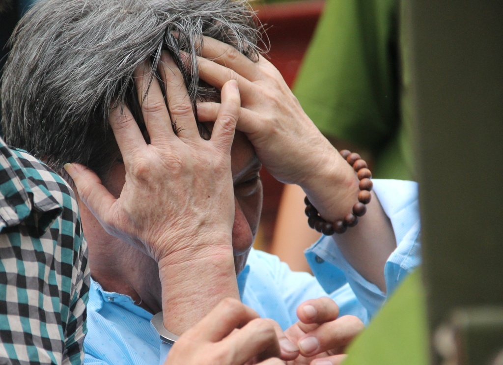 Tân che mặt khi bị dẫn giải sau phiên tòa. Ảnh: Gia đình nạn nhân cung cấp.