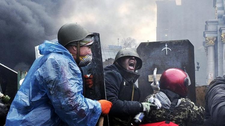 Nhom nguoi bieu tinh dung khien de chong xa thu ban tia hinh anh