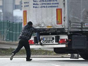 Canh nguoi nhap cu bam vao xe tai de vuot bien hinh anh