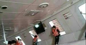 Hành khách mặc áo phao và dựa lưng vào tàu khi nó bắt đầu chìm. Ảnh: Global News/Fact TV.