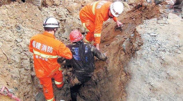 Nạn nhân được đưa lên khỏi hố cát. Ảnh: Daily Mail