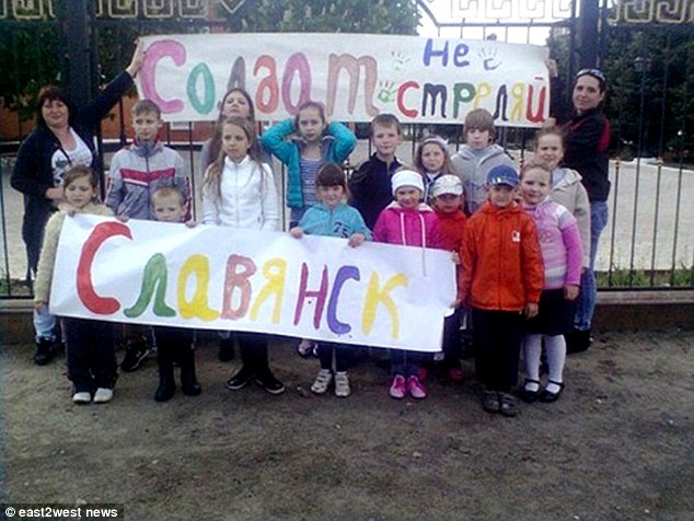 Những đứa trẻ cầm slogan với nội dung khẩn cầu chính quyền Kiev dừng các cuộc tấn công vào thành phố Slaviansk – thành trì của lực lượng ủng hộ Moscow tại miền đông Ukraina. Ảnh: East2West News.