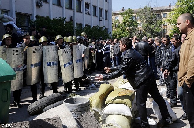 Một người ủng hộ ủng hộ Nga la hét trước cảnh sát Ukraina tại thành phố Mariupol sau khi lực lượng quân đội của Bộ Nội vụ đã giành quyền kiểm soát và xua đuổi người biểu tình khỏi tòa nhà chính quyền thành phố. Ảnh: EPA.