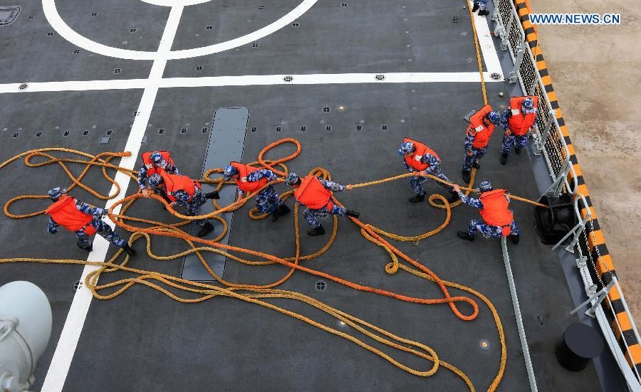 Một máy bay trực thăng đang tiến vào vị trí trong nhà chưa máy bay trên tàu khu trục tên lửa Trịnh Châu.