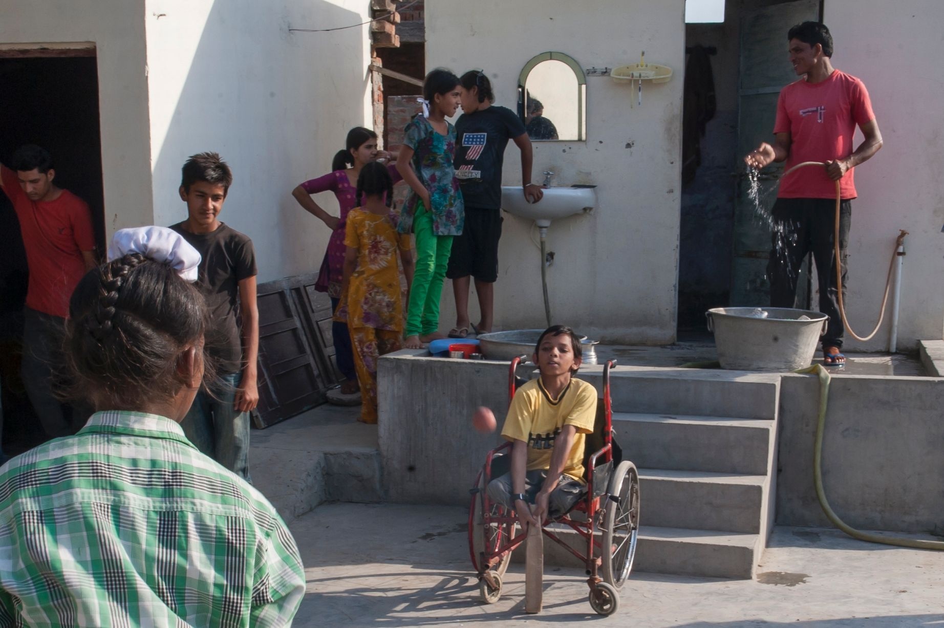 Cậu bé phải ngồi xe lăn vì chiếc đuôi dị tật. Ảnh: