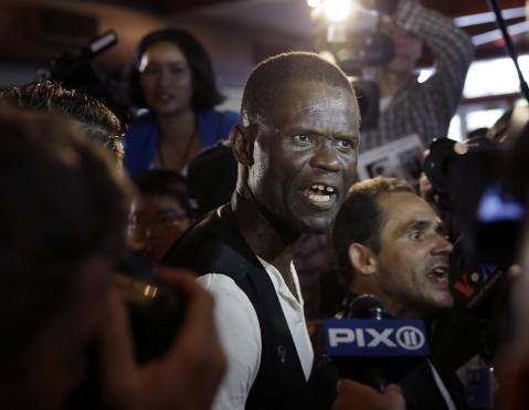 Dân nghèo la ó Trần vì ông không phát tiền cho họ sau bữa trưa. Ảnh: AP. 