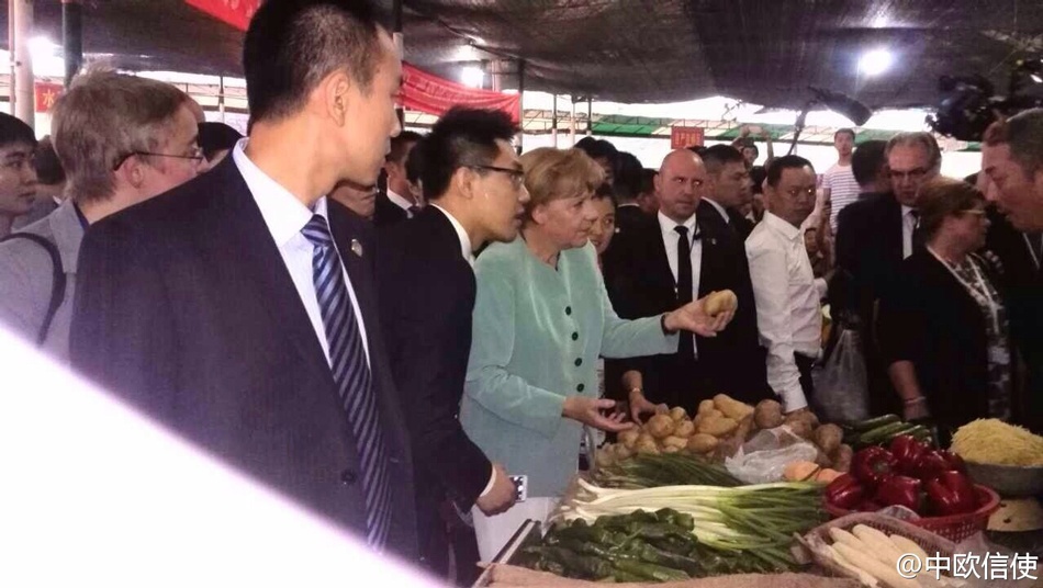 Hầu hết người bán hàng đều không nhận ra nữ Thủ tướng Đức. Thông qua phiên dịch, bà Merkel chăm chú tìm hiểu giá cả từng sản phẩm. Ảnh: China Daily