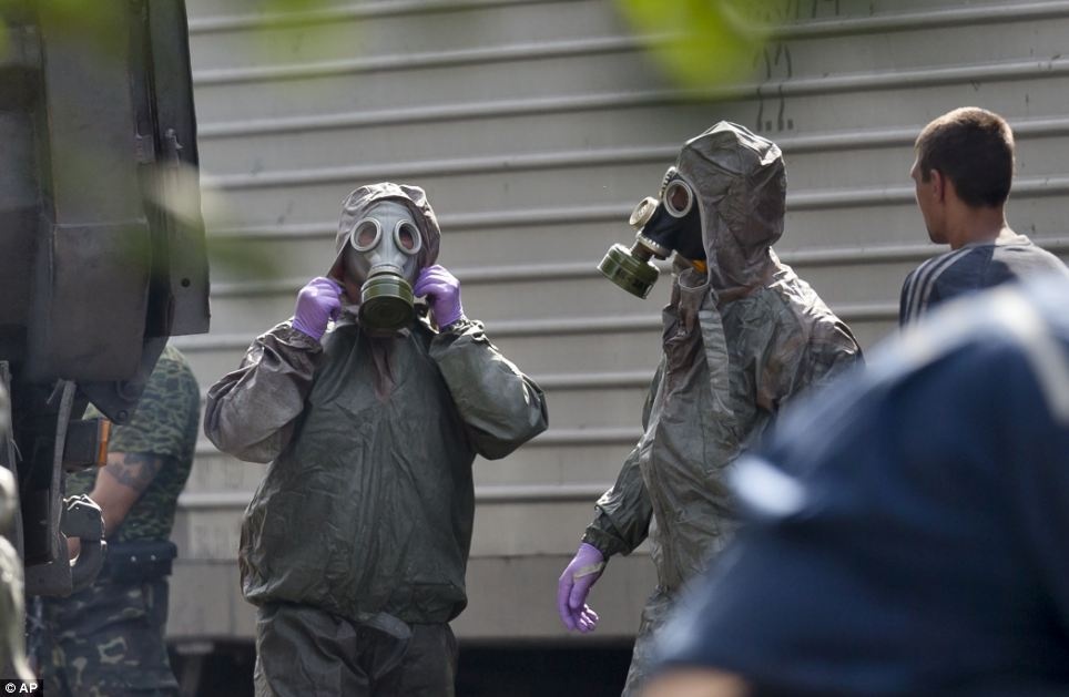 Những người vận chuyển thi thể phải mặc đồ bảo hộ và đeo mặt nạ khi di chuyển thi thể vào túi đựng xác và cất lên xe tải. Nhiều thi thể bị cháy nghiêm trọng do vụ rơi máy bay. Ảnh: AP