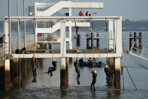 Các học viên leo lên tháp, sau đó nhảy xuống từ độ cao 10 m và bơi khoảng 100 m để trở lại bờ. Thời gian để họ vượt qua thử thách này kéo dài chưa tới 18 phút. Đây là một trong số 5 bài tập quyết định việc các học viên có thể trở thành một thợ lặn chiến đấu hay không. 