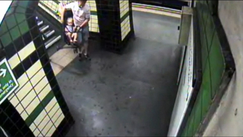 Người đàn ông bê xe đẩy, bên trong là một đứa bé, xuống cầu thang ở phố Goodge, London, Anh vào khoảng 7h30 (giờ địa phương) hôm 23/7.