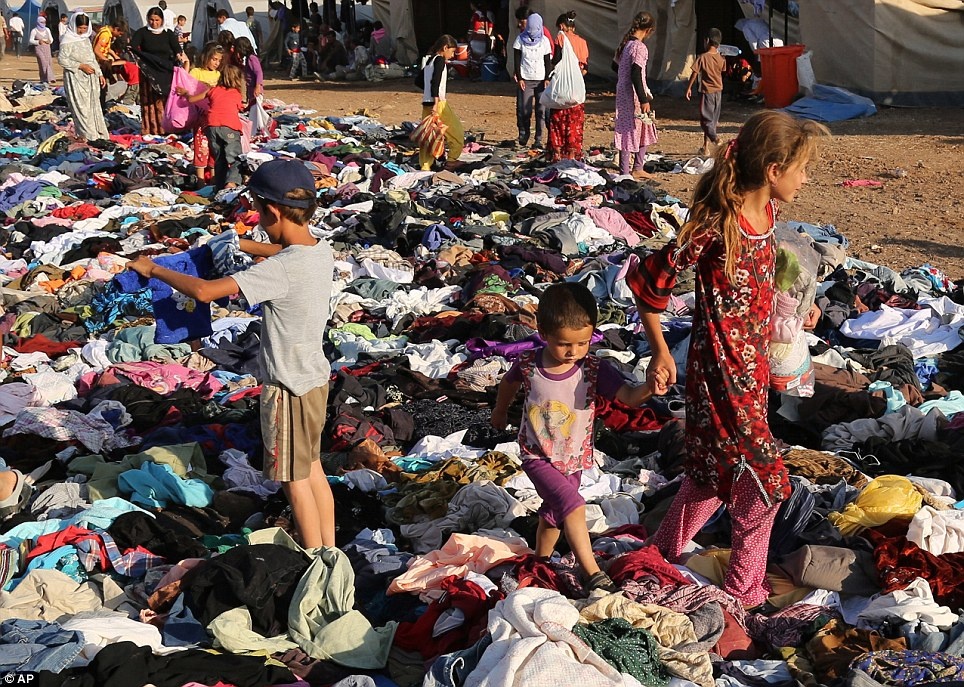 Dòng người tị nạn từ Iraq nhận quần áo từ một tổ chức từ thiện tại trại Nowruz, Derike, Syria. Ảnh: AP