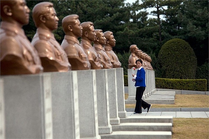 Một cô gái dâng hoa ở nghĩa trang liệt sỹ.