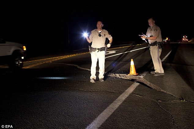 Cơ quan quản lý đại lộ California kiểm tra một vết nứt gãy trên mặt đường vì trận động đất. Ảnh: AP