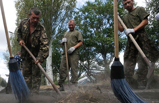 Binh sĩ Ukraine do lực lượng ly khai bắt giữ, bị đưa ra quét đường ở Snizhne, vùng Donetsk ngày 29-8. Có tin các binh sĩ Ukraine bị bắt sắp được trao đổi lấy các lính dù Nga bị bắt vừa qua. Ảnh: Reuters