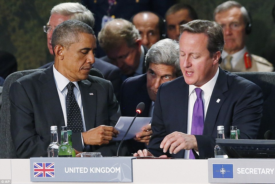 Ngoại trưởng Kerry chuyền cho Tổng thống Obama một mảnh giấy thông báo giữa phiên họp thượng đỉnh của NATO. Ảnh: AP