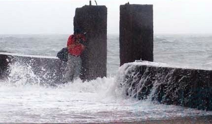Bất chấp mối nguy hiểm từ những đợt sóng dữ tợn, nhiếp ảnh gia vẫn nép người bên đê chắn sóng để không bỏ lỡ từng khoảnh khắc 