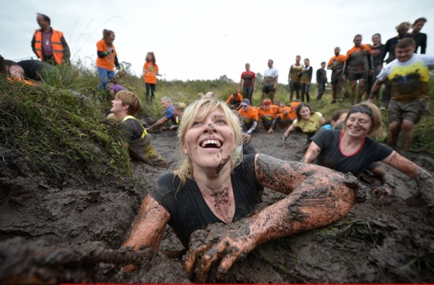 Những người tham gia cuộc thi vừa phải giữ thăng bằng, vừa phải chạy đua với nhau khi lội qua vũng lầy.