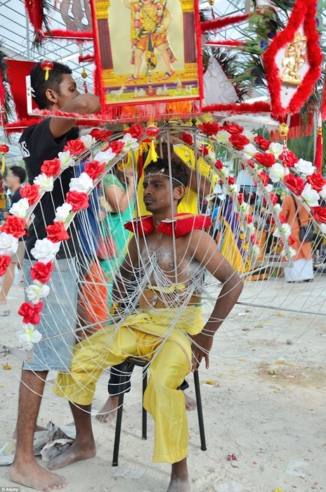 Người đàn ông móc các dây xích sắt vào cơ thể.