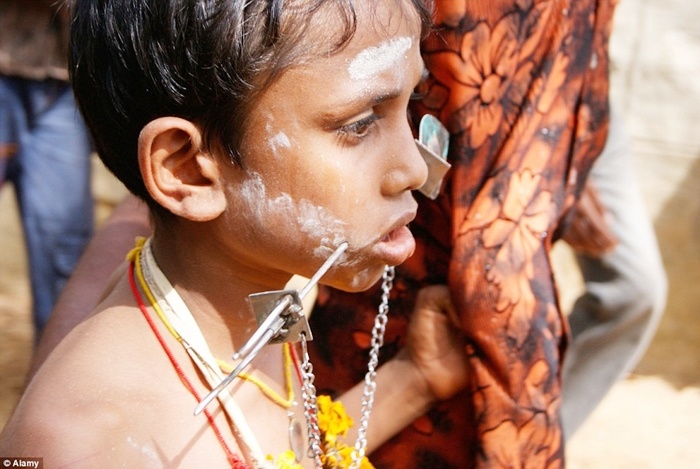 Một cậu bé cũng tham gia vào lễ hội với cây thép xuyên 2 má.