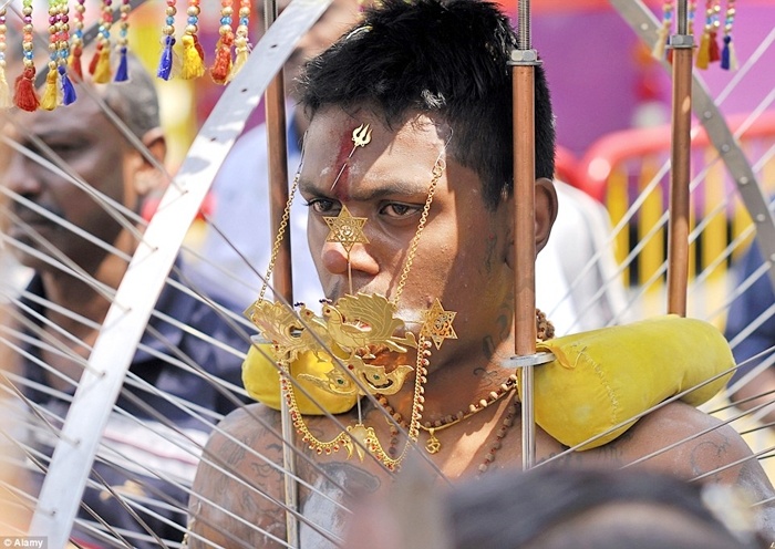 Người đàn ông móc chi chít xích sắt vào người.