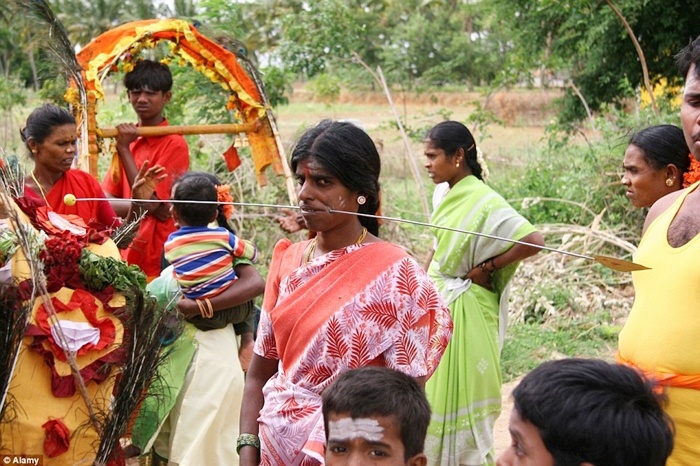 Người phụ nữ với thanh sắt cực dài xuyên qua má.