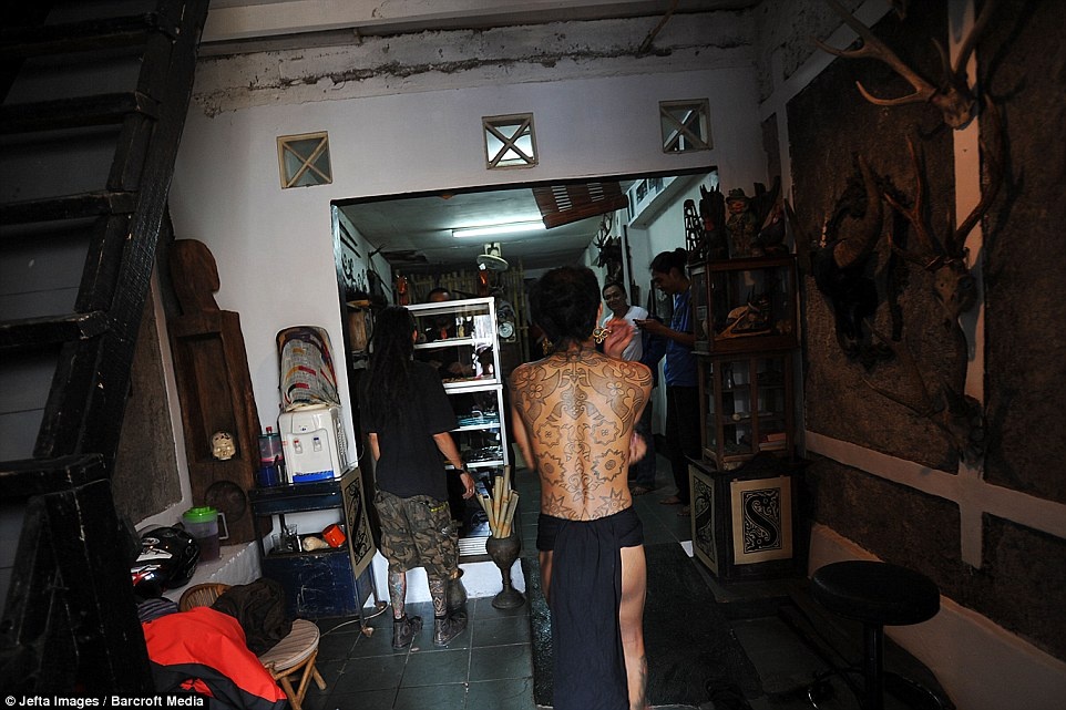 Khách xăm mình tại cửa hàng của anh Ranu Khodir. Những người trải nghiệm kĩ thuật xăm truyền thống nói việc xăm bằng tay khá đau, và âm thanh hai thanh gỗ đập liên tục vào nhau khiến họ nhức đầu.