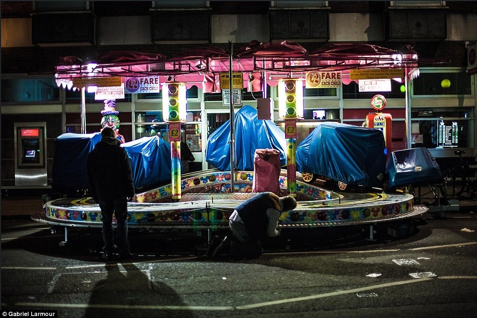 Nhiếp ảnh gia Garbial Larmour chụp cảnh hai người đàn ông đang sửa chữa tại một khu vực vui chơi trong hội chợ Fun Fair ở London, Anh, lúc 2 giờ sáng.