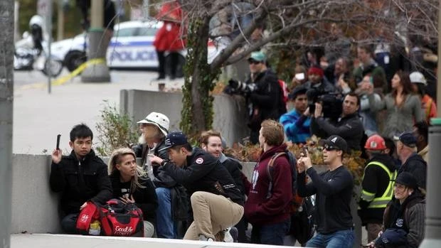 Người dân đi quanh tòa nhà quốc hội tìm chỗ ẩn náu sau khi hay tin vụ nổ súng.