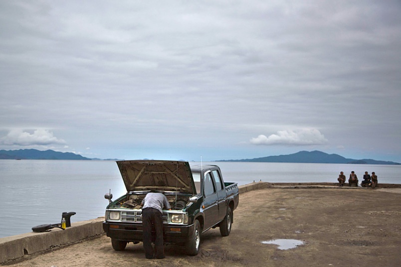 Một người đàn ông sửa xe bên bờ biển ở Wonsan.