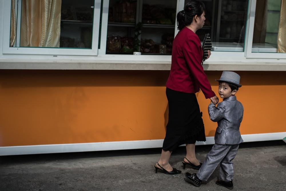 Một người phụ nữ dắt con trai trên một tuyến phố tại thủ đô.