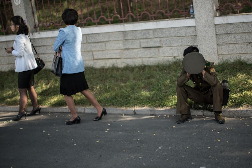 Một binh sĩ ngồi nghỉ tại ven đường.