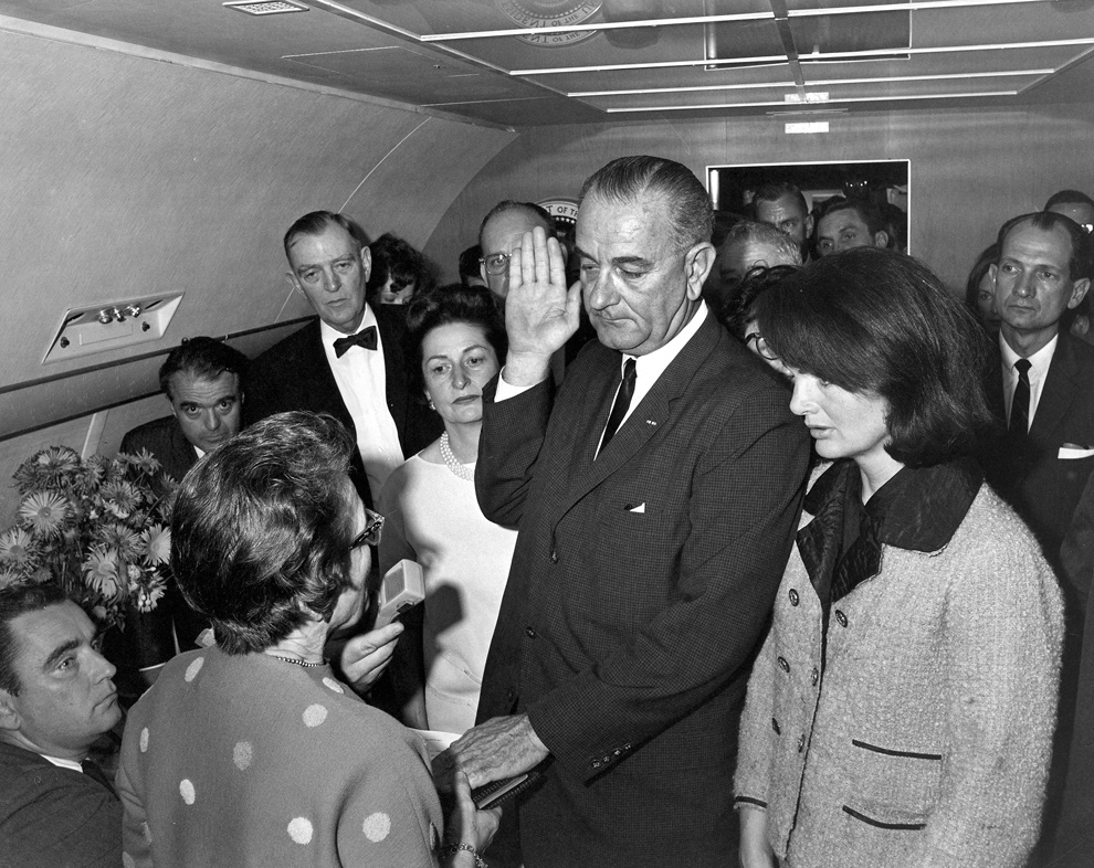 Ông Lyndon B. Johnson tuyên thệ nhậm chức Tổng thống Mỹ, kế nhiệm ông Kennedy, ngay trong chiếc Không lực 1 đậu ở Dallas vào chiều 22/11.