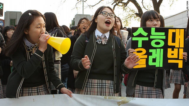 Tại trường trung học dành cho nữ sinh Pungmoon ở thành phố Seoul, các em học sinh khóa dưới cầm biểu ngữ khích lệ tinh thần và gửi những lời chúc may mắn, tới các chị khóa trên chuẩn bị bước vào phòng thi. 