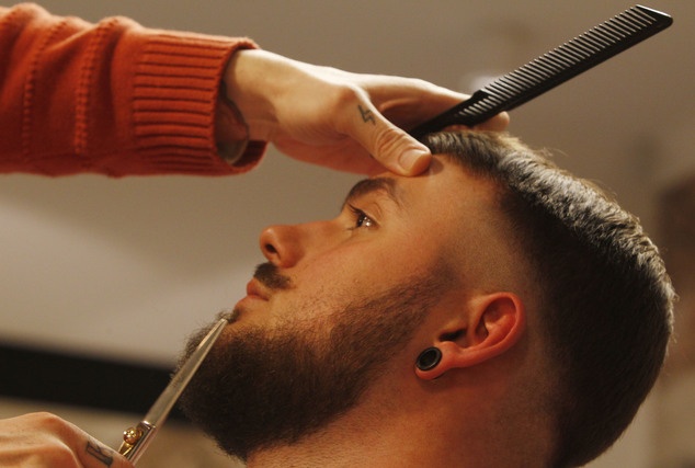 Khách hàng chăm sóc râu tại một cửa tiệm ở thủ đô Warsaw, Ba Lan. Ảnh: AP