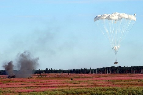 Một xe quân sự được thả từ máy bay xuống. Ảnh: Infonet