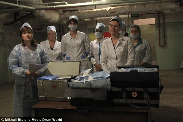 Nhân viên y tế trong hầm bên bộ dụng cụ mà họ sẽ dùng để chăm sóc cho những người bị thương hoặc đau bệnh.