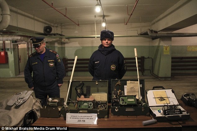 Nhân viên an ninh canh gác tại hầm bên cạnh những dụng cụ phát hiện phóng xạ đời cũ và mặt nạ chống khí độc.