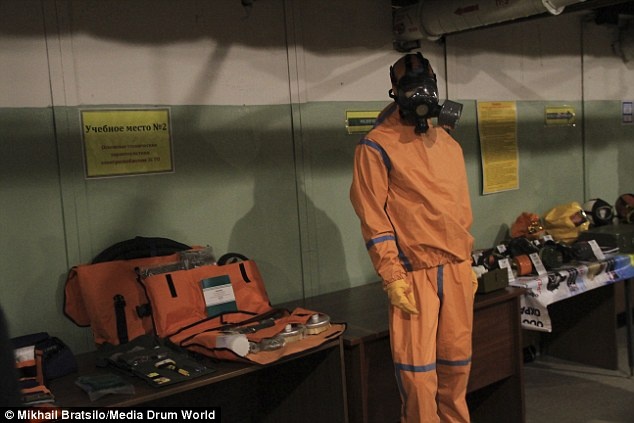 Một nhân viên hướng dẫn cách mặc đồ bảo vệ tại hầm.