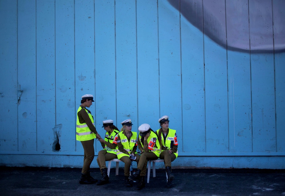 Nữ cảnh sát Israel ngồi đợi chuẩn bị kiểm tra số tên lửa từ một tàu chở hàng của Panama bị chặn ở bờ biển Sudan vào tháng 3/2014. Năm 2009, lần đầu tiên trong lịch sử Israel, Thiếu tướng Ahuva Tomer được bổ nhiệm vị trí sĩ quan chỉ huy quản lý lực lượng cảnh sát ở Haifa, thành phố lớn nhất miền bắc Israel, theo YNet news. Bà Tomer cũng là nữ chỉ huy duy nhất trong số 60 vị chỉ huy cảnh sát trên cả nước. Phụ nữ chiếm chưa tới 1/4 trong lực lượng 27.500 chiến sĩ cảnh sát của Israel. 