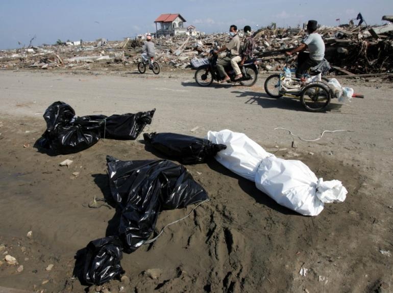 Nhân viên cứu hộ mang bọc đựng thi thể một nạn nhân sóng thần đến nhà thờ lớn ở thành phố Banda ngày 29/12/2004. Các nhà thờ trở thành nơi đặt thi thể nạn nhân tạm thời sau trận thiên tai. Ảnh: Boston