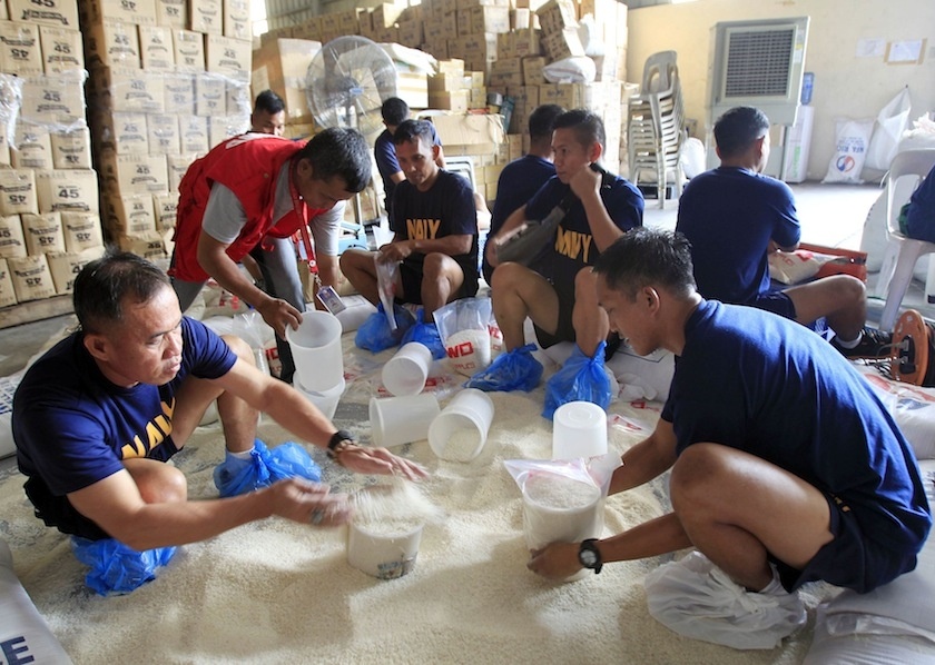 Nhân viên và tình nguyện viên thuộc Bộ Phúc lợi và Phát triển xã hội chuẩn bị gạo và thực phẩm cứu trợ ở Manila để phân phát cho người dân tại những vùng bị ảnh hưởng trong cơn bão. Ảnh: Reuters