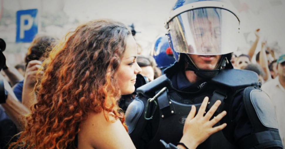 Một cô gái trẻ bất ngờ ôm một sĩ quan cảnh sát trong một cuộc biểu tình phản đối chính sách thắt lưng buộc bụng và tăng thuế thuế của chính phủ tại Lisbon, Bồ Đào Nha, năm 2012.