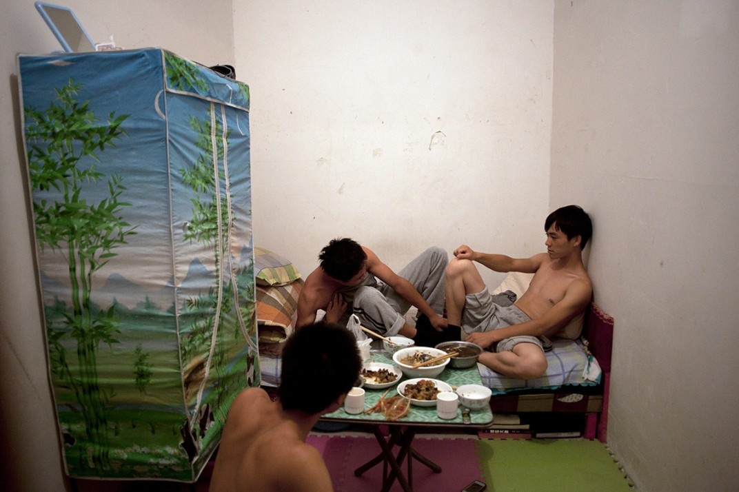 Một nhóm công nhân xây dựng trong căn phòng chật hẹp ở Bắc Kinh mà họ đã thuê trong 6 tháng qua. Những thanh niên này đến từ tỉnh Hà Bắc. Trong tương lai, họ có thể không còn được tiếp tục thuê vì những chính sách mới của thành phố. Tháng 12/2010, chính quyền thủ đô ban hành quy định mới hạn chế việc cho thuê phòng dưới tầng hầm, đặt mục tiêu giảm dần việc xây dựng và lưu trú tại những phòng trọ này vì cho rằng chúng 