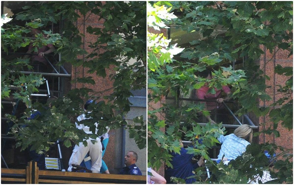 Cảnh sát đang giúp một phụ nữ thoát hiểm khỏi căn phòng phía trên quán cafe Lindt.