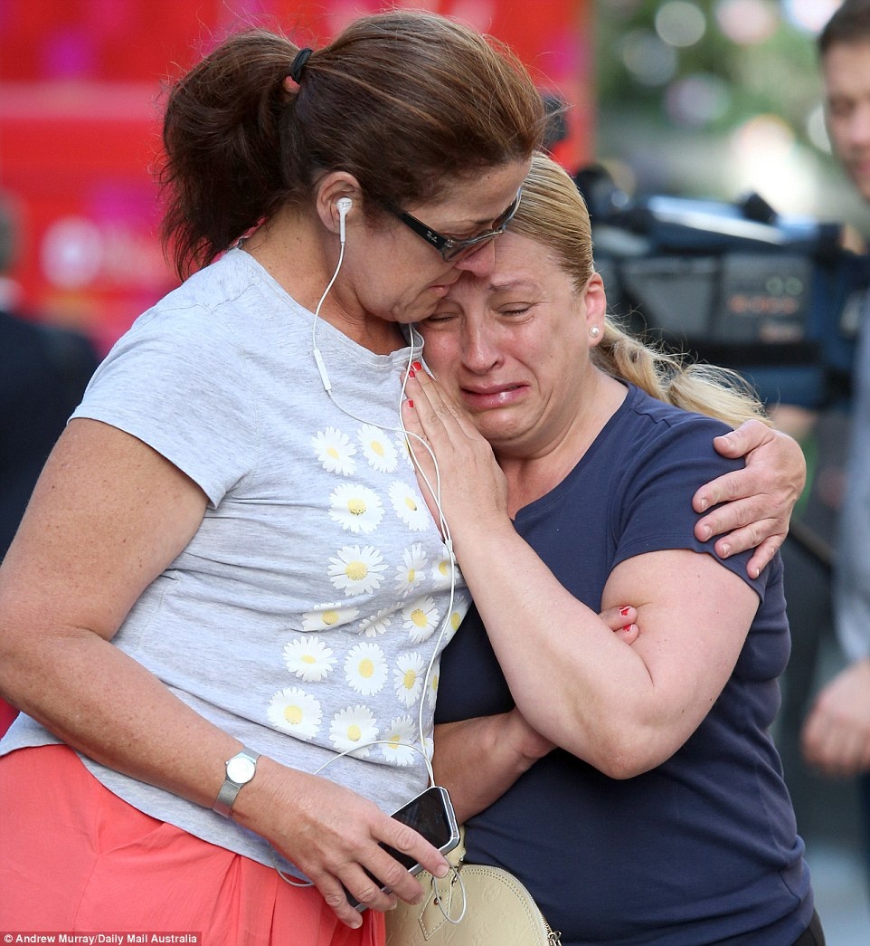 Terri Lucia (phải) khóc nức nở không kiểm soát được khi đặt hoa tại một ngôi đền tạm cho nạn nhân