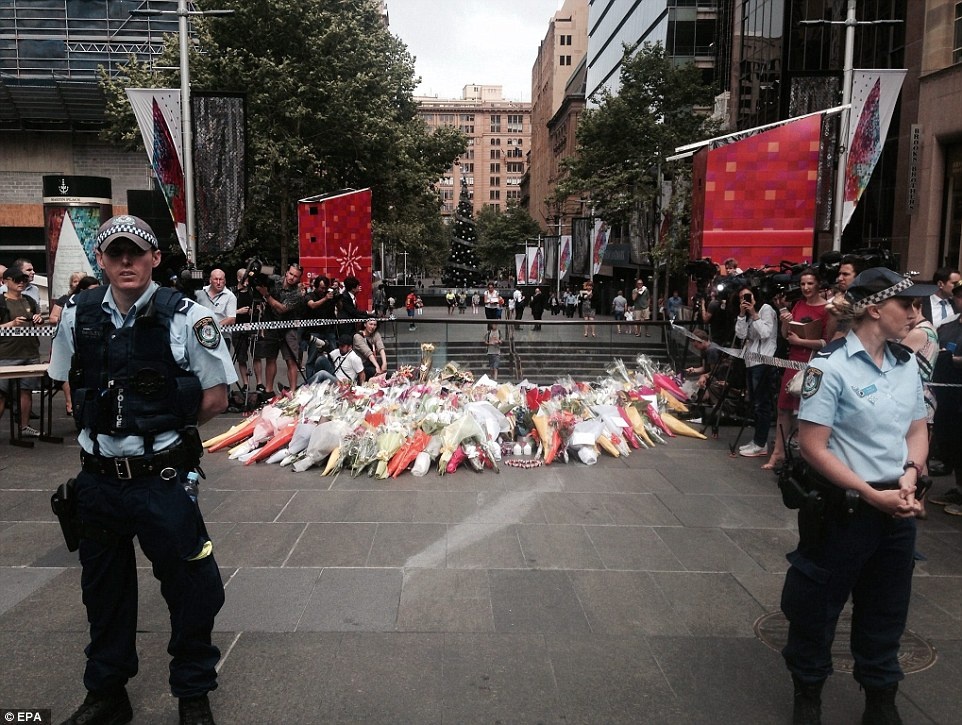 Bé gái 4 tuổi đặt vòng hoa tại khu tưởng niệm tạm thời tại khu Martin Place.  Không khí tang thương bao trùm toàn khu vực trung tâm Sydney. Một khu vực tưởng niệm tạm thời đã được lập.  Ảnh: EPA