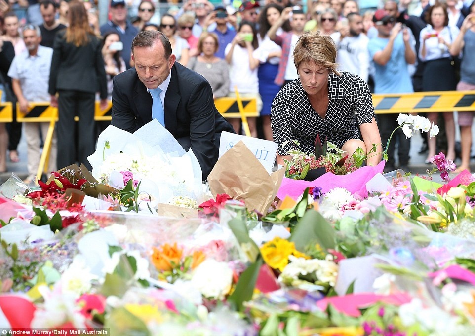 Thủ tướng Australia Tony Abbott cùng phu nhân, bà Margie, đặt hoa tại khu vực tưởng niệm những nạn nhân thiệt mạng trong vụ bắt cóc con tin chấn động kéo dài 16 tiếng. 