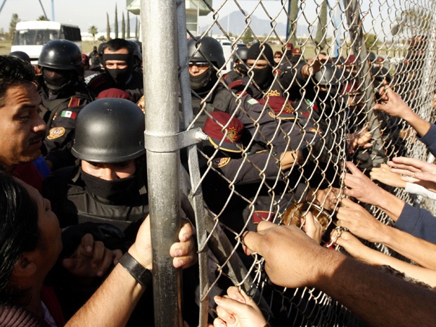 Cảnh sát ngăn cản cuộc biểu tình của gia đình tù nhân thiệt mạng trong cuộc ẩu đả giữa hai băng nhóm ở nhà tù tại Mexico năm 2012. Ảnh: AFP