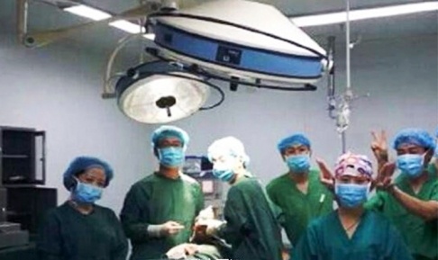 Bức ảnh các y, bác sĩ tạo dáng trong lúc phẫu thuật cho bệnh nhân gây tranh cãi. Ảnh: SCMP